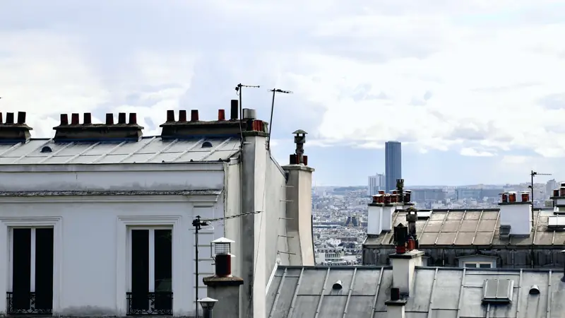 Toits en zinc et cheminées de Paris, avec la tour Montparnasse au loin