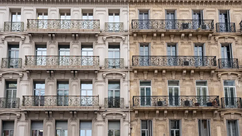 Façades d'immeubles anciens en pierre de taille avec balcons en fer forgé alignés sur plusieurs étages