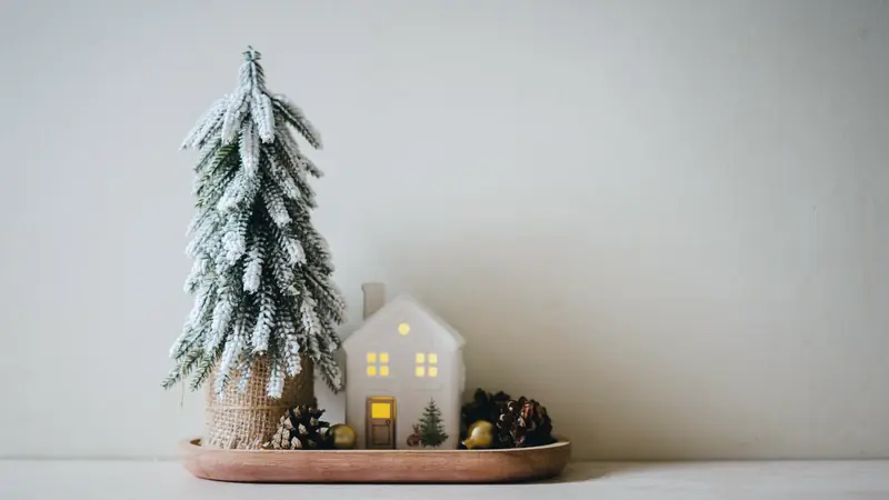 Maquette de maison et pièces de monnaie empilées sur une table