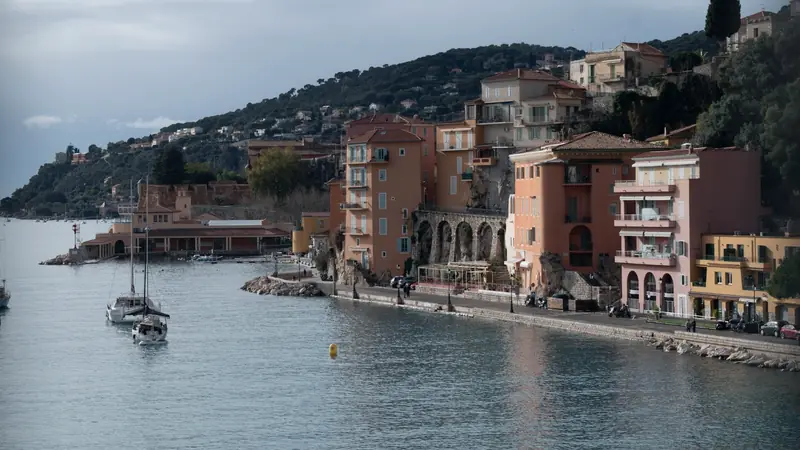 Vue sur la rade de Villefranche-sur-Mer, ses bateaux au mouillage et les collines boisées