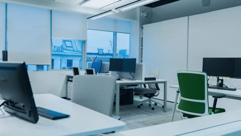 Bureau aménagé avec postes de travail, chaises et grandes fenêtres